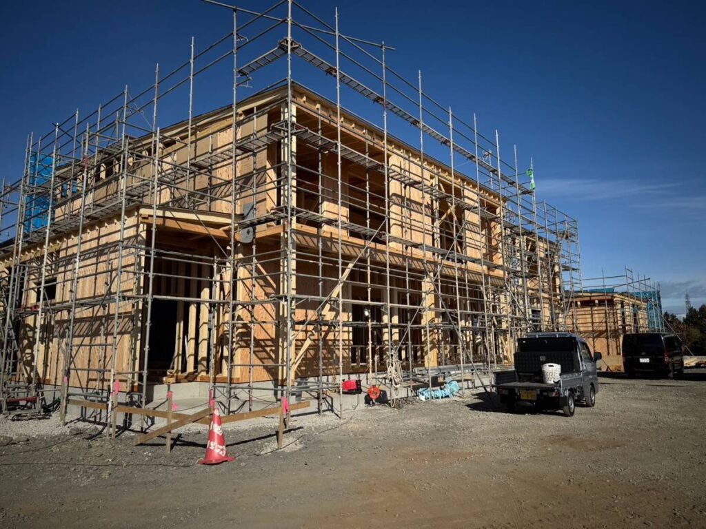 青空の下で進む木造住宅の建設現場